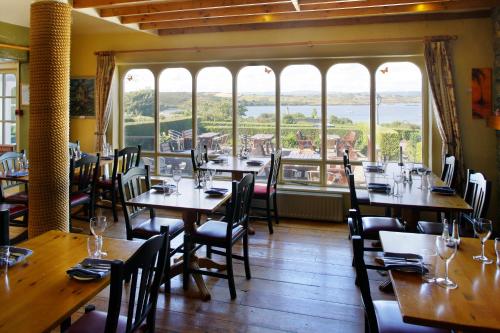 a restaurant with wooden tables and chairs and large windows at Casey's Of Baltimore Collection in Baltimore