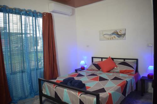 a bedroom with a bed and a large window at B&B Il Padrino in Puerto Jiménez