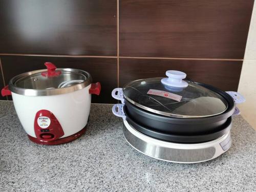 a slow cooker and a pot on a counter at Homezstay Permyjaya Miri in Miri