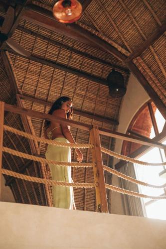 a woman standing on a balcony talking on a cell phone at Lulu's Villas in Uluwatu