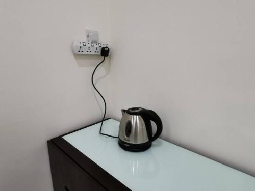 a tea kettle sitting on top of a dresser at Homezstay Permyjaya Miri in Miri