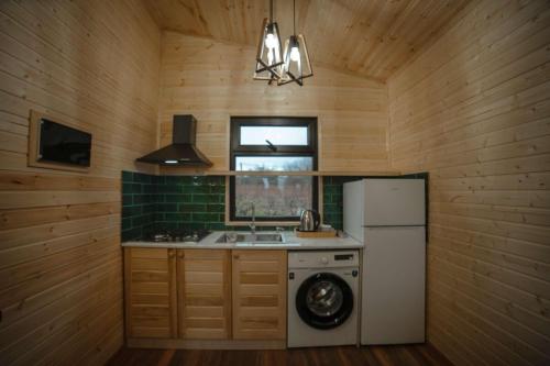 a kitchen with a sink and a white refrigerator at Matilda Village in Tʼelavi