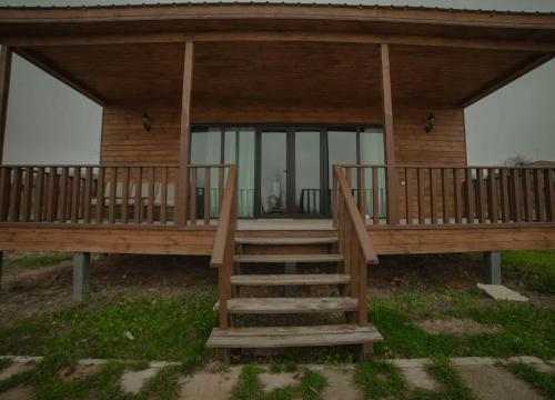 a screened in porch with stairs leading to a house at Matilda Village in Tʼelavi