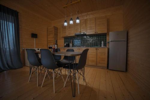 a kitchen with a table and chairs and a refrigerator at Matilda Village in Tʼelavi