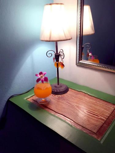 a table with a lamp and a vase with a flower at Klai Hat Inn in Hua Hin