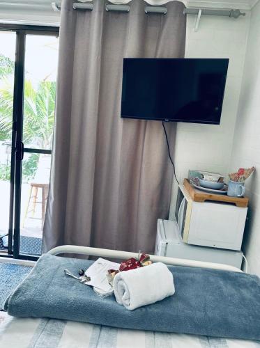a room with a tv and a bed with a towel at Garden View Homestay Single Ensuite Room in Catalina