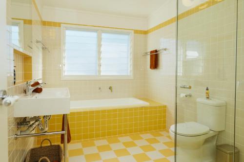 ヤンバにあるBAY PROPERTIES . The Sailors Upper Deckの浴槽、トイレ、洗面台を備えたバスルーム