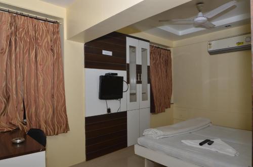 a room with a bed and a tv in it at Da Casa Business Hotel in Pune