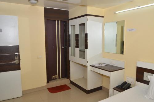 a bathroom with a bed and a sink and a mirror at Da Casa Business Hotel in Pune