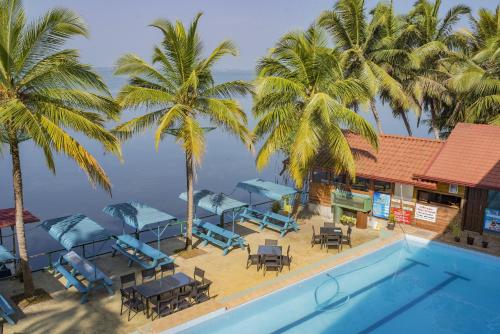 a resort with a swimming pool and palm trees at New Saniro Lagoon Deck in Katunayaka