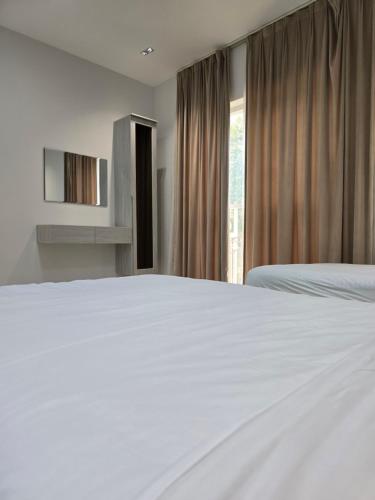 a bedroom with a white bed and a window at Hatta Orchard in Hatta