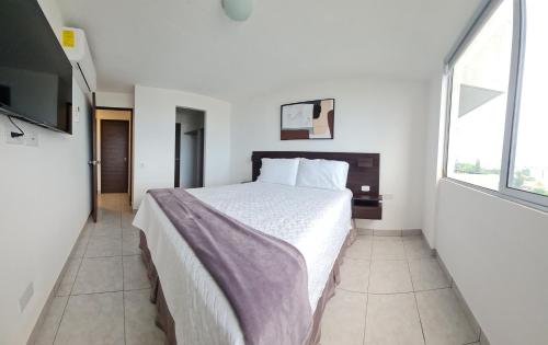 a bedroom with a large bed and a large window at Condo 9, San Francisco Tower in San Salvador