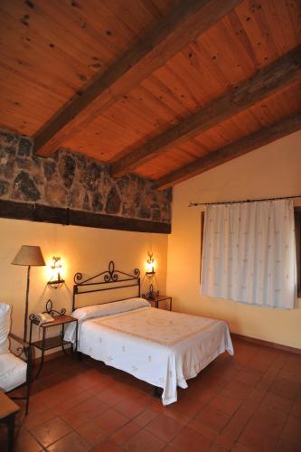 a bedroom with a bed and a wooden ceiling at Hotel Rural Hosteria Fontivieja TR-CC-195 in Losar de la Vera