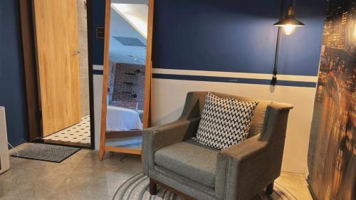 a chair with a pillow in front of a mirror at Chill Roof Hotel in Taipei