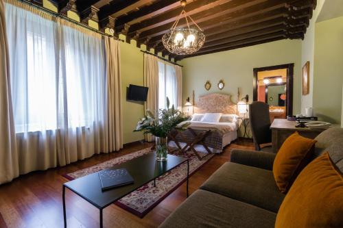 a living room with a couch and a bed at Palacio de Mariana Pineda in Granada