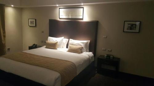 a hotel room with a bed with white sheets and pillows at Savoy Hotel Boutique in Las Terrenas