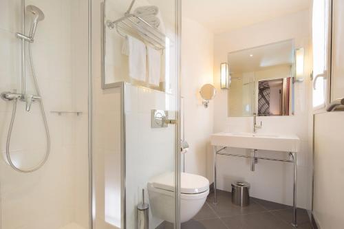 a bathroom with a shower and a toilet and a sink at Hôtel Gustave in Paris