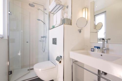 a bathroom with a toilet and a sink and a shower at Hôtel Gustave in Paris