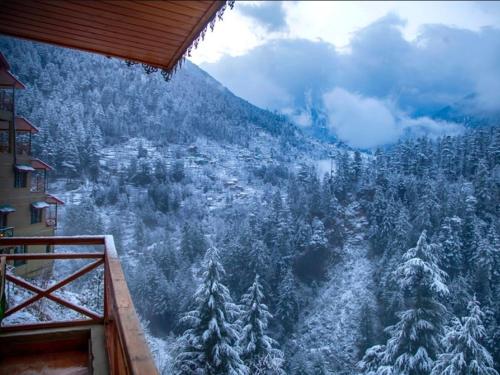 a room with a view of a snow covered forest at Jalori House in Jibhi
