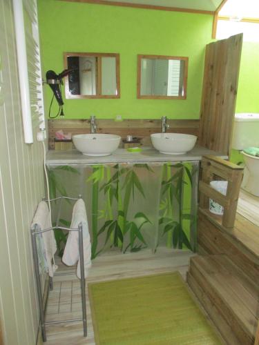 La salle de bains est pourvue de 2 lavabos et d'un mur vert. dans l'établissement Chambres d'Hôtes Roseland, à Paray-le-Monial