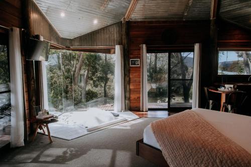 a bedroom with a bed and a large window at Eagle View Escape in Rydal