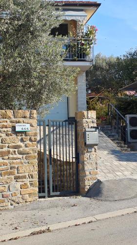 a house with a gate and a balcony with flowers at Apartments Tomišić in Koper