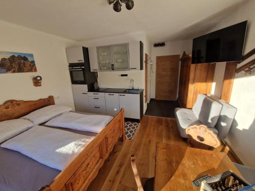 a bedroom with a bed and a desk and a television at Bergidyll Ramsau Top7 in Ramsau am Dachstein