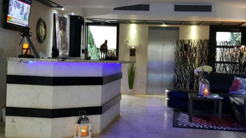 a lobby with a bar with a couch and a tv at Savoy Hotel Boutique in Las Terrenas
