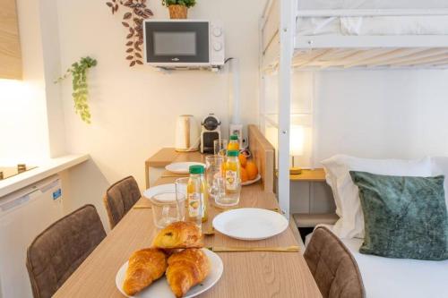 - une table à manger avec 2 assiettes de pain dans l'établissement Amazing stylish studio, well located near metro, Bastille neighborhood, à Paris