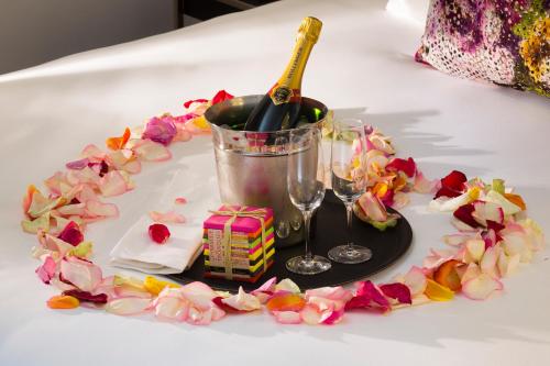 a table with a plate with a bottle of wine and flowers at Hôtel Gustave in Paris