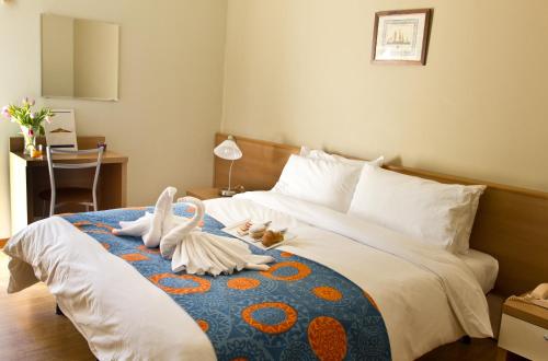 Un dormitorio con una cama con dos cisnes. en Hotel La Fenice, en Lignano Sabbiadoro