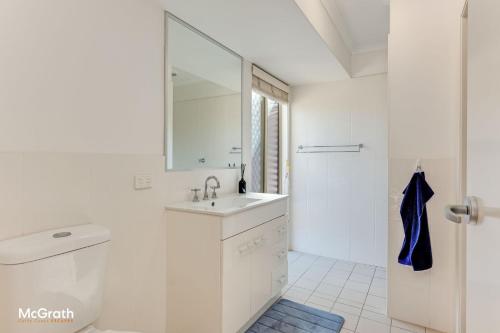 a white bathroom with a sink and a mirror at Sparkling Waters in Toormina