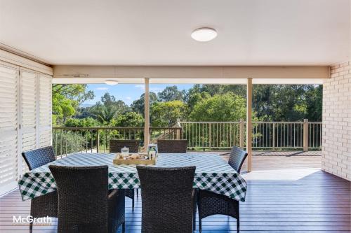 a dining table and chairs on a deck with a view at Sparkling Waters in Toormina