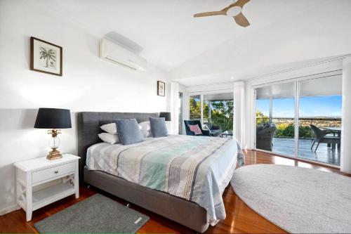 a bedroom with a bed and a view of a patio at Pacific Vista in Coffs Harbour
