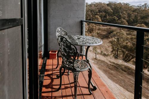 a table and a chair sitting on a balcony at Eagle View Escape in Rydal