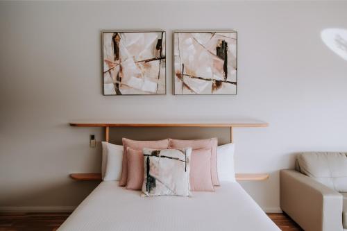 a bedroom with a bed with pink and white pillows at Eagle View Escape in Rydal