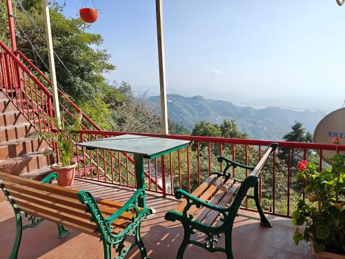 a table and two benches sitting on a balcony at Beechwood Holiday Apartments in Mussoorie