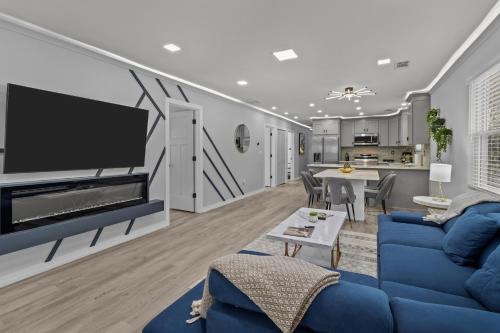 a living room with a blue couch and a tv at Charlotte Retreat: Luxury 4BR Heaven in Charlotte