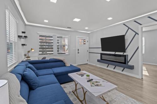 a living room with a blue couch and a tv at Charlotte Retreat: Luxury 4BR Heaven in Charlotte