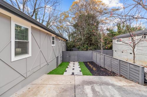 a backyard with a fence and grass next to a house at Charlotte Retreat: Luxury 4BR Heaven in Charlotte