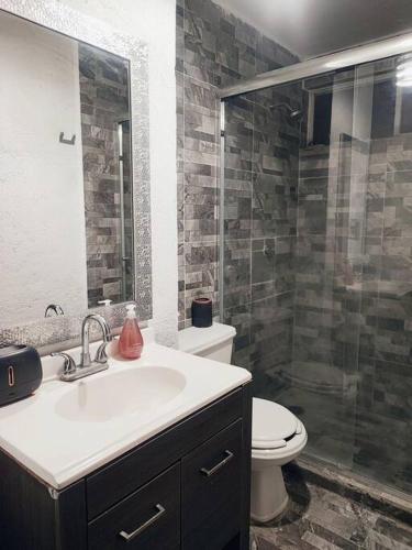 a bathroom with a toilet and a sink and a shower at Departamento en Paseo de la Reforma CDMX in Mexico City