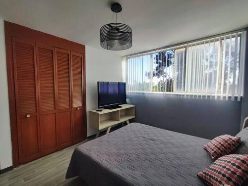 a bedroom with a bed and a television in it at Departamento en Paseo de la Reforma CDMX in Mexico City