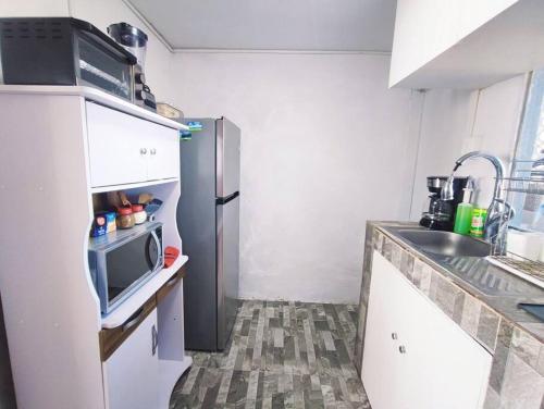 a small kitchen with a refrigerator and a microwave at Departamento en Paseo de la Reforma CDMX in Mexico City