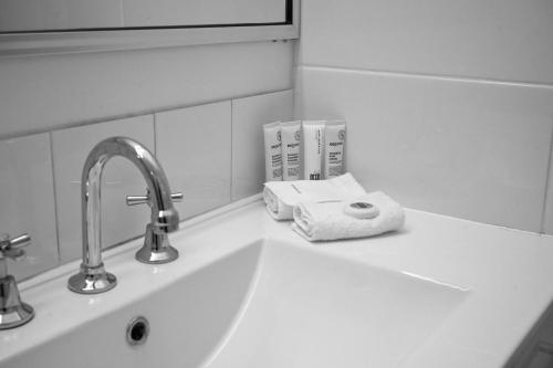 a bathroom sink with a faucet and towels on it at Holbrook Town Centre Motor Inn in Holbrook