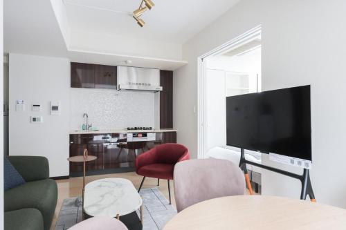 a living room with a tv and a kitchen at Las Pacios Azabu Kougai-cho Residence in Tokyo