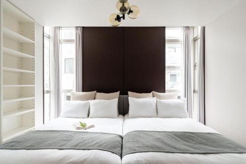 a bedroom with a large bed with white pillows at Las Pacios Azabu Kougai-cho Residence in Tokyo