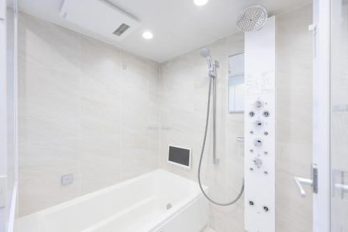 a white bathroom with a tub and a shower at Las Pacios Azabu Kougai-cho Residence in Tokyo