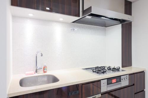 a kitchen with a sink and a stove at Las Pacios Azabu Kougai-cho Residence in Tokyo