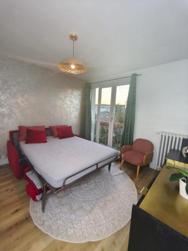 - une chambre avec un lit doté d'oreillers rouges dans l'établissement charmant appartement neuf et cosy, à Bondy