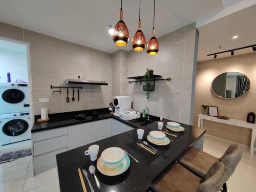 una cucina con un tavolo con sedie e un piano di lavoro di IPOH Sunway Onsen Suites and Tambun GuestHouse by uBook a Tambun